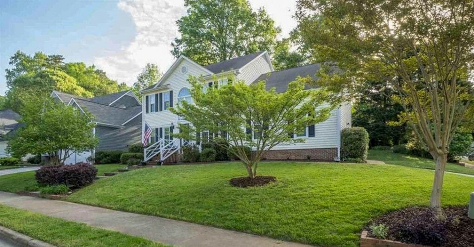 A home with a thick, green lawn from a lawn aeration and over seed service.