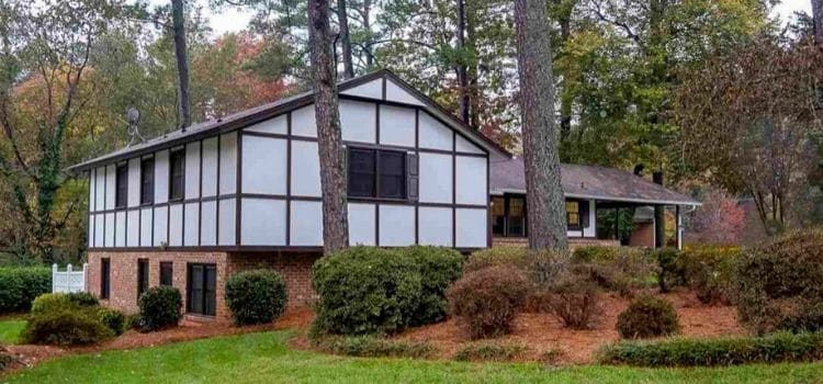 Landscape beds with pine straw surrounding a wooded home.